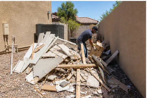 Side yard junk removal cleanup with construction debris and discarded materials being cleared