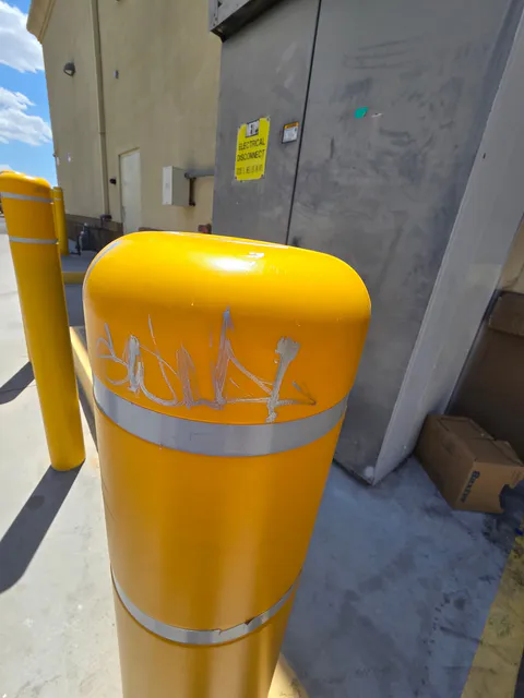 Commercial yellow bollard cleanup and exterior safety repair photo